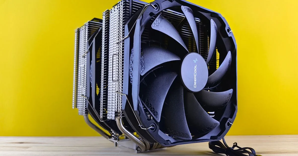 Un ventilateur de refroidissement CPU haute performance avec dissipateur de chaleur placé sur une surface en bois contre un fond jaune vif.